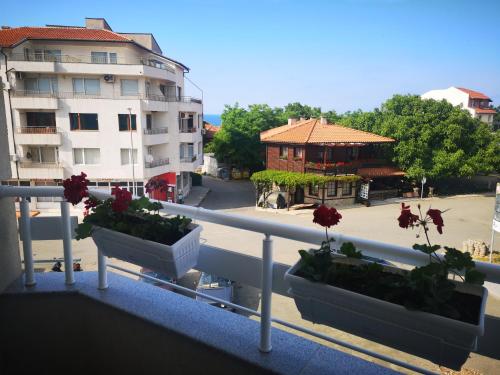 a balcony with some flowers in pots on a railing at Hiora Apartments Vasiliko in Tsarevo