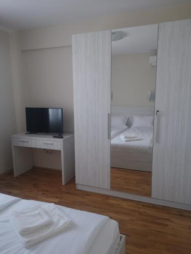 a room with a bed and a tv and a mirror at Hiora Apartments Vasiliko in Tsarevo