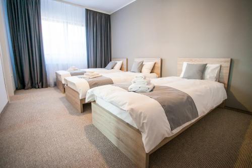 a bedroom with two beds with a teddy bear sitting on them at Pensiunea Sada in Cluj-Napoca