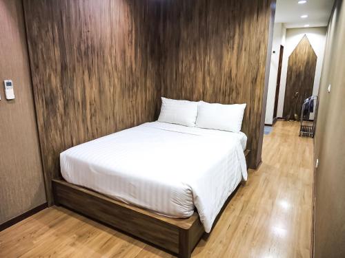 a bed in a room with a wooden wall at Baan Keang Chon Ayutthaya บ้านเคียงชล อยุธยา in Phra Nakhon Si Ayutthaya
