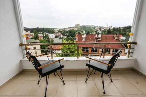 a balcony with two chairs and a view of a city at Thermal Saray Hotel & Yalova in Gokcedere