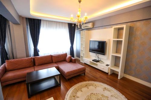a living room with a couch and a tv at Thermal Saray Hotel & Yalova in Gokcedere