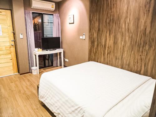 a bedroom with a white bed and a television at Baan Keang Chon Ayutthaya บ้านเคียงชล อยุธยา in Phra Nakhon Si Ayutthaya
