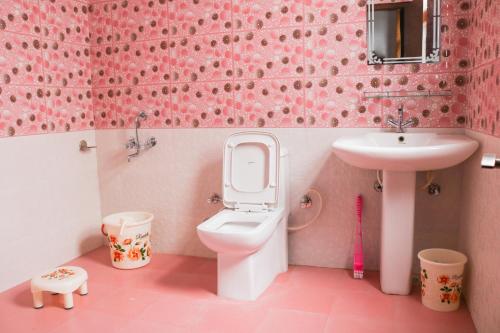 a pink bathroom with a toilet and a sink at Sai Alok homestay in Shimla