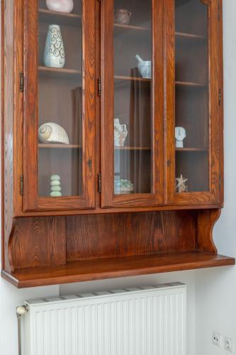 a wooden cabinet with dishes in it on a wall at Thea Suites Naxos in Agios Prokopios
