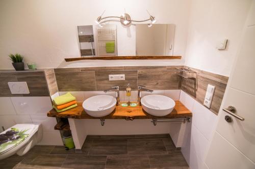 a bathroom with two sinks and a mirror at Ferienhaus am Apfelbaum in Andernach