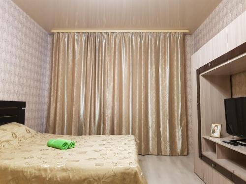 sypialnia z łóżkiem z zieloną butelką w obiekcie Улучшенные апартаменты на Ауре w mieście Surgut