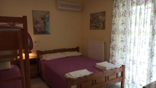 a small bedroom with a bed and a window at Studios Ermis in Kalamitsi