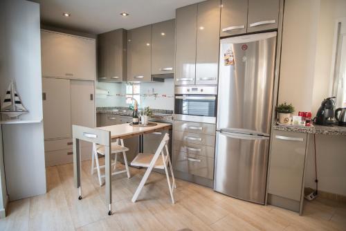 a kitchen with a table and a refrigerator at El Pont Alicante Apartments in Alicante