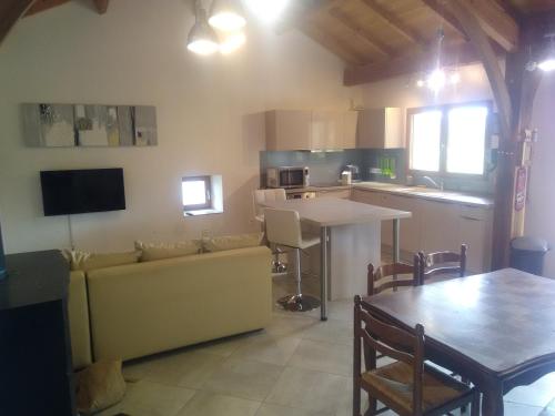 een keuken en een woonkamer met een bank en een tafel bij gite de Jade in Montaigu-de-Quercy