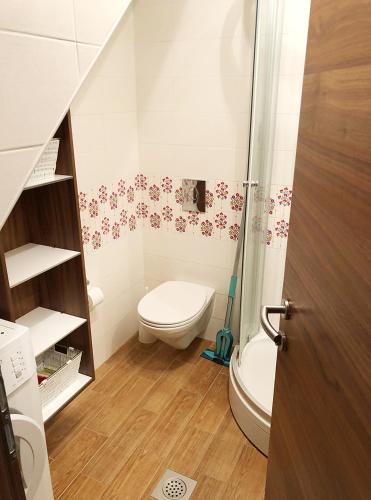 a small bathroom with a toilet and a shower at Soline Home - holiday house - self check-in in Brela