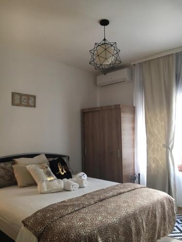 una camera da letto con un letto grande e un lampadario di Apartment Smile a Mostar