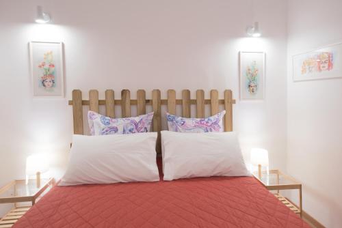 een slaapkamer met een rood bed met 2 kussens bij Casa Annuccia ai Quattro Canti di Città in Palermo