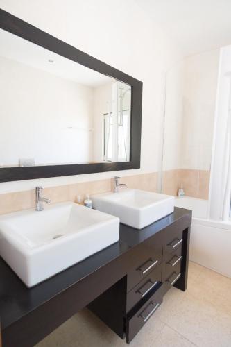 a bathroom with two sinks and a large mirror at Villa Ria Rose, Alto da Ria 23 - jacuzzi and beach in Alvor