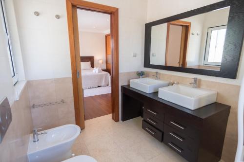 Baño con 2 lavabos y espejo en Villa Ria Rose, Alto da Ria 23 - jacuzzi and beach, en Alvor