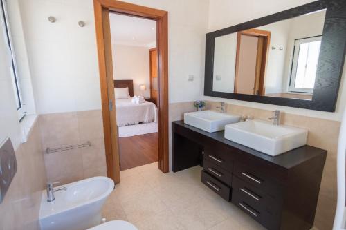 a bathroom with two sinks and a mirror at Villa Ria Rose, Alto da Ria 23 - jacuzzi and beach in Alvor