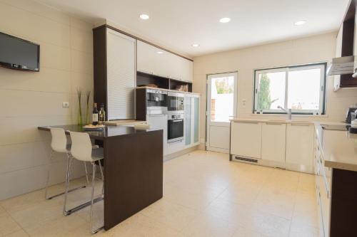 a kitchen with a counter and a stove top oven at Villa Ria Rose, Alto da Ria 23 - jacuzzi and beach in Alvor