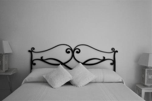 a bed with a black and white headboard and pillows at Sogno Mediterraneo in Formia