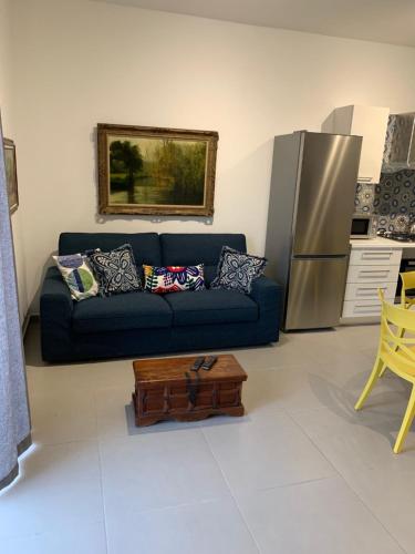 a living room with a blue couch and a refrigerator at Island Break Residence in Marsalforn