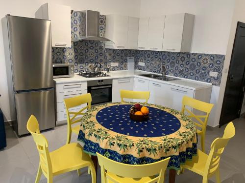 a kitchen with a table with a bowl of fruit on it at Island Break Residence in Marsalforn