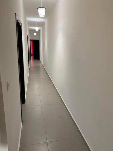 a long hallway with white walls and white tile floors at Island Break Residence in Marsalforn