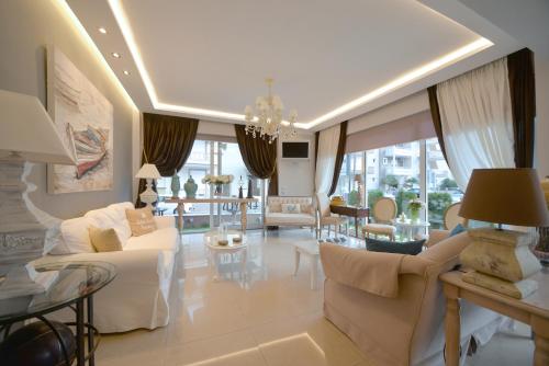 a living room with white furniture and a large window at Epavlis Luxury apts in Leptokaria