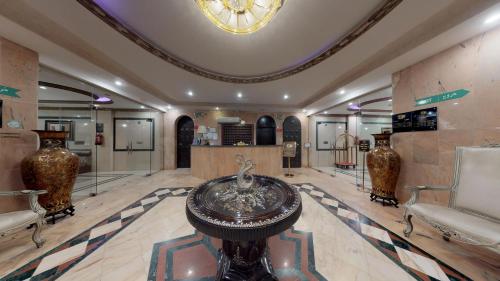 a lobby with vases and a table and chairs at شاطئ البساتين للشقق المخدومة in Jeddah