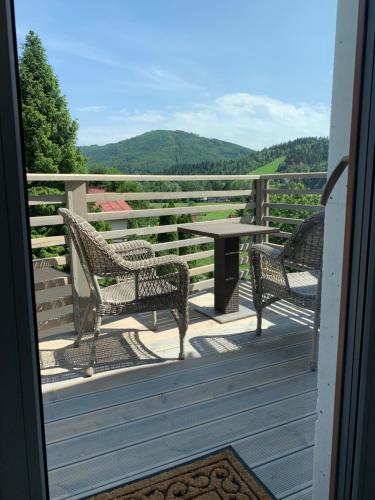 a porch with two chairs and a table with a view at Kwaterka in Brenna