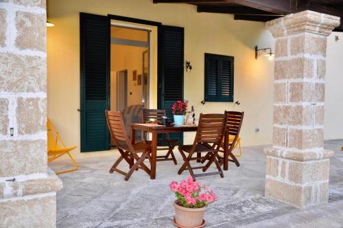 a patio with a wooden table and chairs at Villa Emanuel in Alessano