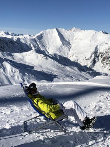 a man sitting on a sled in the snow at Pension Rosenegg in Finkenberg