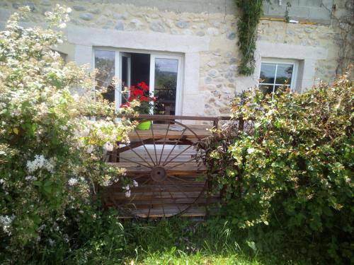 a wooden bench in front of a house with flowers at OKAMI DU VERCORS in Saint-Laurent-en-Royans