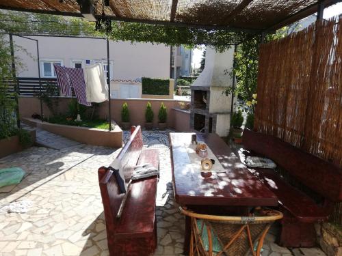 een patio met een houten tafel en stoelen bij family apartman luka in Rovinj