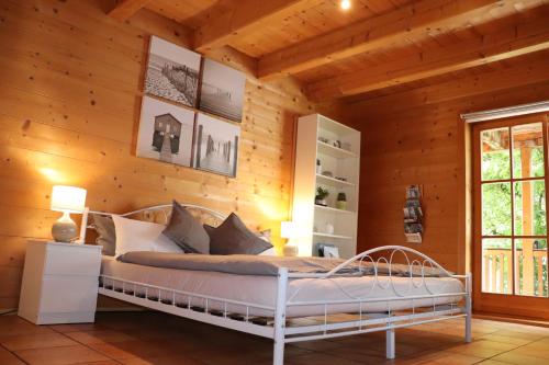 ein Schlafzimmer mit einem Bett in einer Holzwand in der Unterkunft Studio im Blockhaus am Chiemsee in Bernau am Chiemsee