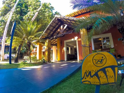 ein Haus mit einem gelben Schild davor in der Unterkunft Pousada Tatuapara in Praia do Forte