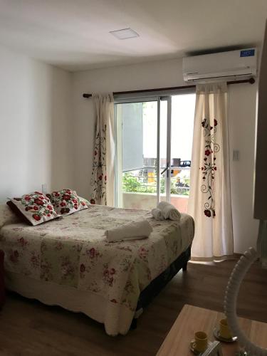 a bedroom with a bed and a large window at Aires Verdes de Salta in Salta