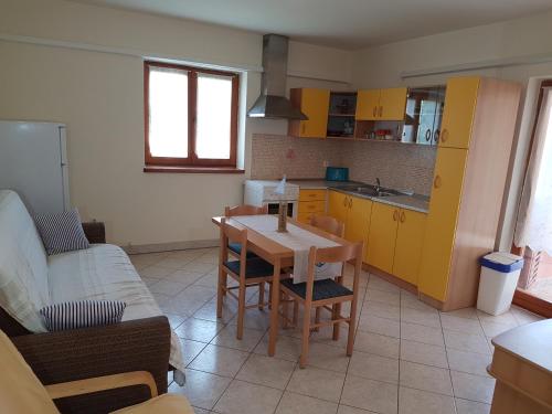 a kitchen with a table and a kitchen with yellow cabinets at Apartments Iva in Pula