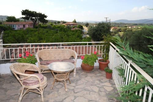 a patio with chairs and a table on a balcony at Art Flowers and Culture in Mystras