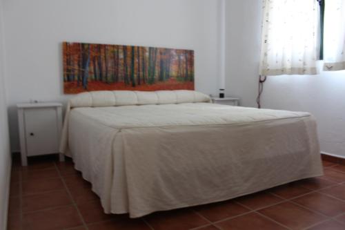 タリファにあるBella Vista Tarifaの白いベッド1台付きのベッドルーム1室(壁に絵画付)