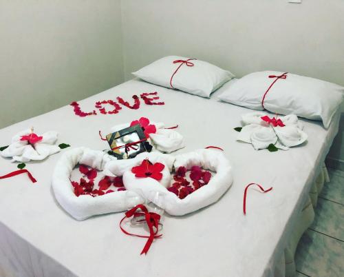 a bed with two hearts and flowers on it at Pousada do Holandês in Canoa Quebrada