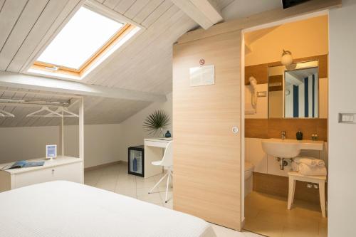 a bedroom with a bed and a sink and a skylight at Civico 64 Bed & Breakfast in mansarda in Palmi