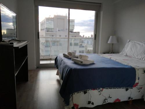 ein Schlafzimmer mit einem Bett und einem großen Fenster in der Unterkunft Palermo viejo in Buenos Aires