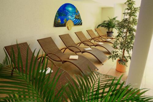 a row of chairs in a waiting room with plants at Hotel-Restaurant Walserhof in Wasserburg am Bodensee