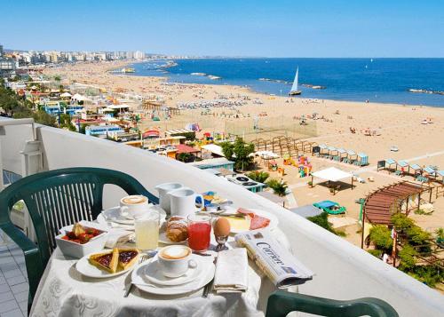 a table with food and a view of a beach at Park Hotel Cattolica & Restaurant in Cattolica