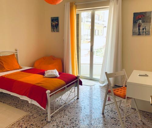 sypialnia z łóżkiem, oknem i biurkiem w obiekcie Small Apartment in Markopoulo center w mieście Markopoulo Mesogaias