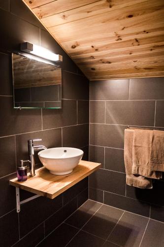 a bathroom with a bowl sink on a wooden shelf at Nant Morzine in Morzine