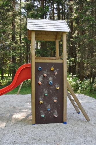 a playground with a rock wall and a slide at Penzion Mezi lesy in Nové Hutě