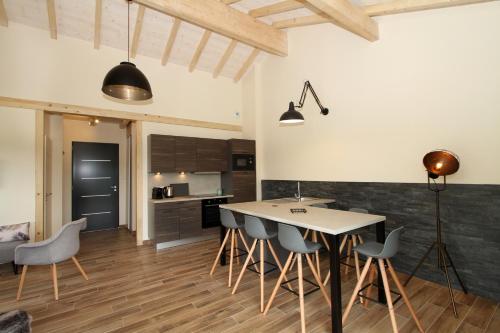 une cuisine avec une table et des chaises dans une pièce dans l'établissement Le Balcon des Lumières, à Gérardmer