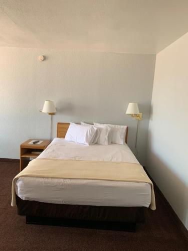 a bedroom with a large bed with two lamps at EZ 8 Motel Airporter in Phoenix