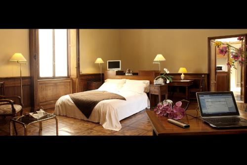 a bedroom with a bed and a desk with a laptop at Residence In Centro in Mantova