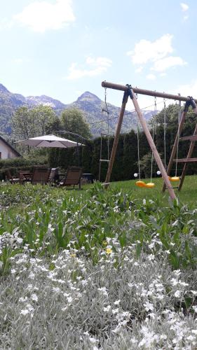 a playground with a swing in a field of flowers at Snežak (Snowman) in Bohinj